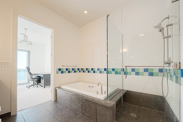 bathroom featuring plus walk in shower, tile walls, and tile patterned floors