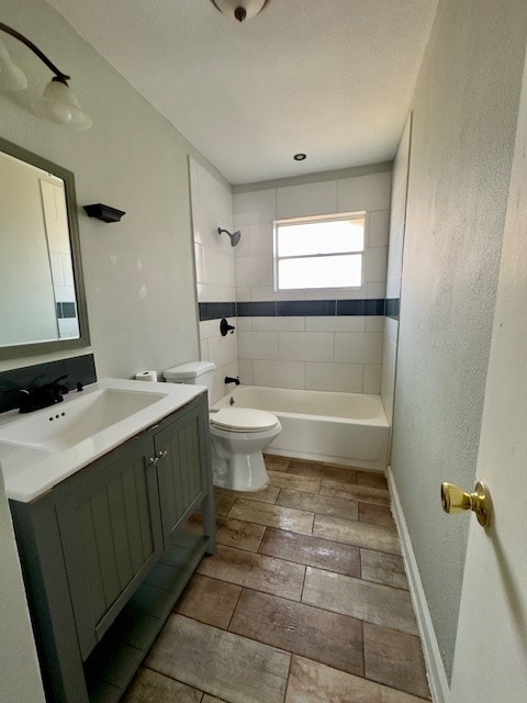 full bathroom featuring tiled shower / bath combo, vanity, and toilet