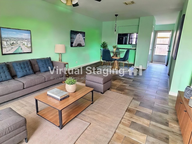 living room with ceiling fan and light wood-type flooring