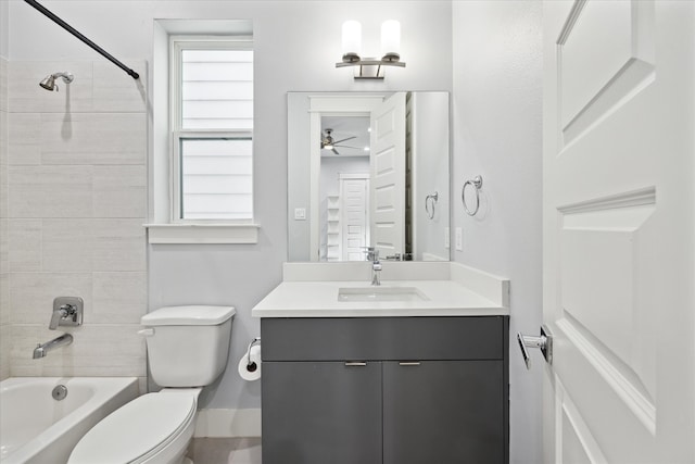 full bathroom with ceiling fan, vanity, tiled shower / bath combo, and toilet