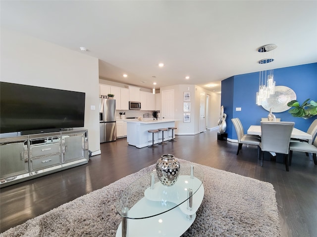 living room featuring a notable chandelier and dark hardwood / wood-style floors