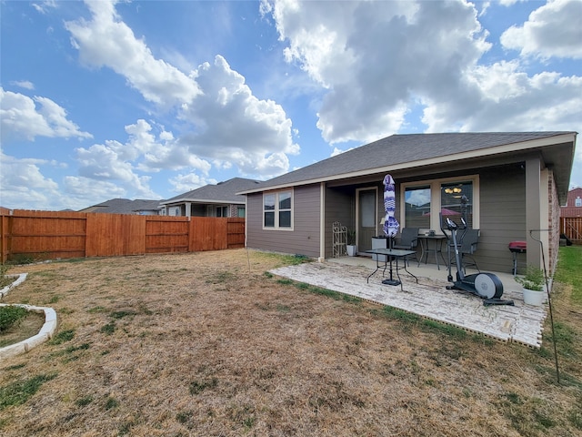 back of property with a lawn and a patio area