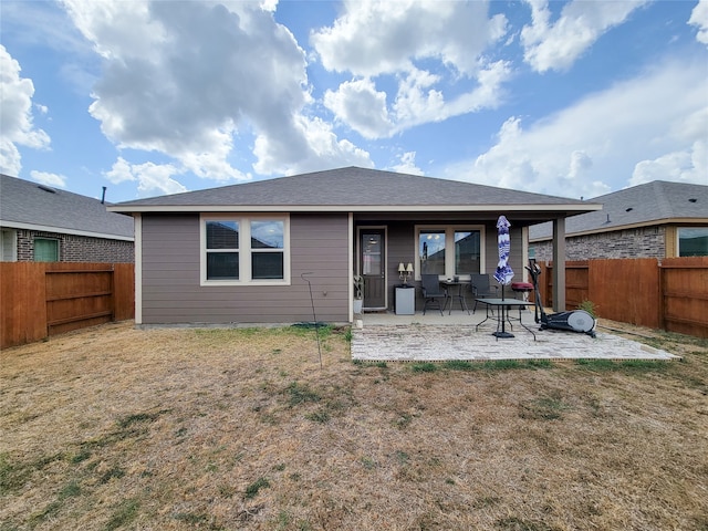 rear view of house featuring a lawn and a patio area