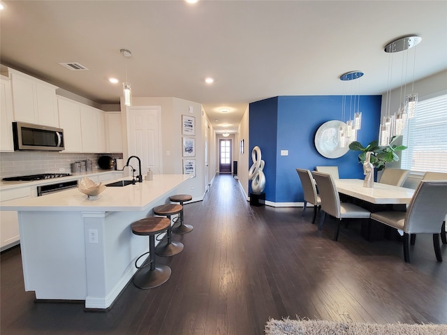 kitchen with plenty of natural light, decorative backsplash, dark hardwood / wood-style flooring, and hanging light fixtures