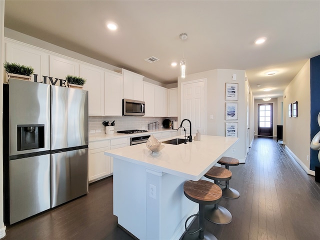 kitchen featuring decorative backsplash, dark hardwood / wood-style flooring, white cabinets, sink, and stainless steel appliances