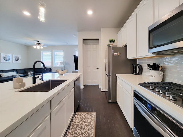 kitchen featuring dark wood-type flooring, tasteful backsplash, white cabinetry, appliances with stainless steel finishes, and sink