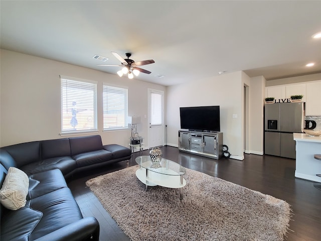 living room with dark hardwood / wood-style flooring and ceiling fan