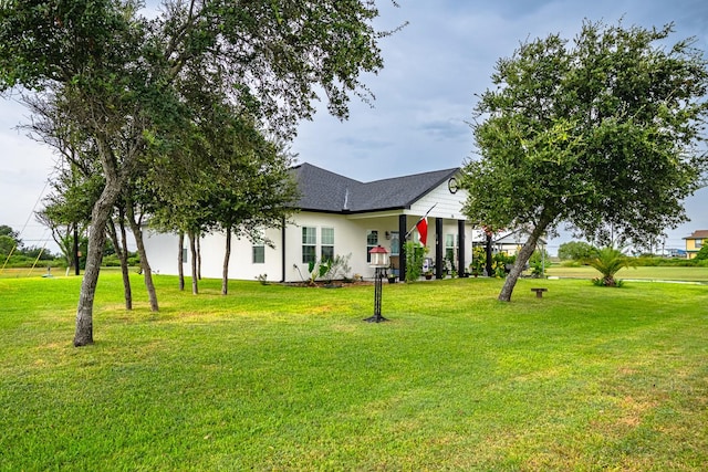 exterior space with roof with shingles and a front yard