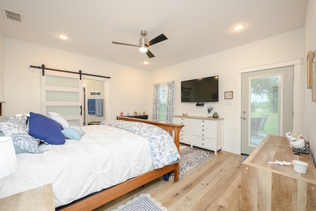 bedroom featuring access to exterior, recessed lighting, visible vents, a barn door, and light wood-style floors