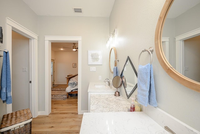 bathroom featuring baseboards, visible vents, connected bathroom, wood finished floors, and vanity