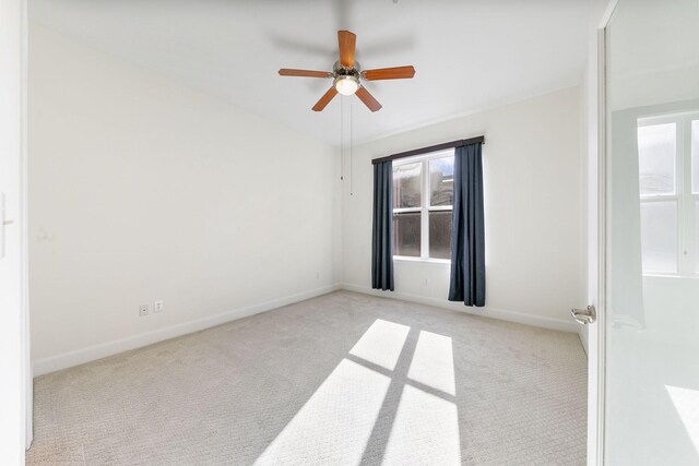 empty room featuring ceiling fan and light colored carpet