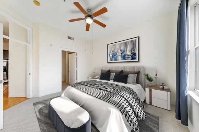 bedroom with ceiling fan and light colored carpet