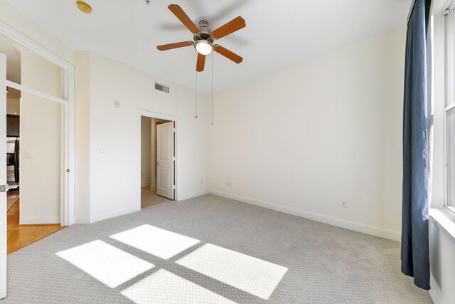 unfurnished bedroom with light colored carpet and ceiling fan