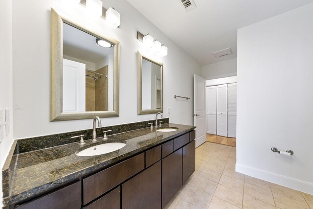 bathroom featuring tile patterned flooring, vanity, and walk in shower