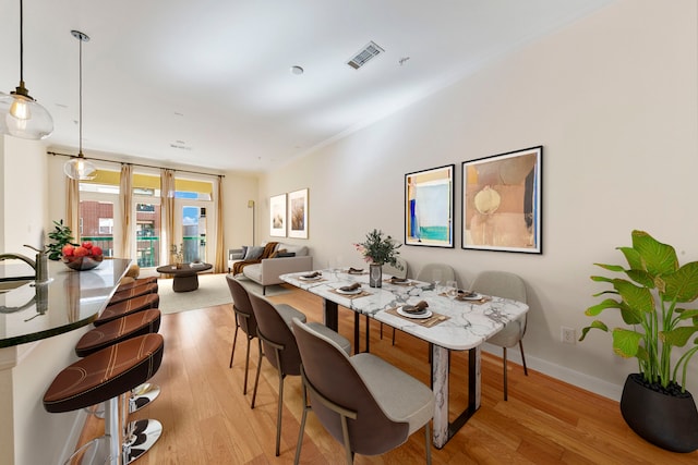 dining area with sink and light wood-type flooring