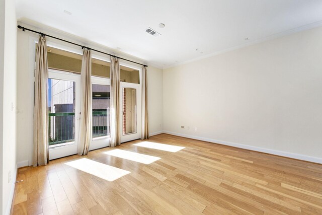 unfurnished room with a wealth of natural light, crown molding, and light hardwood / wood-style floors