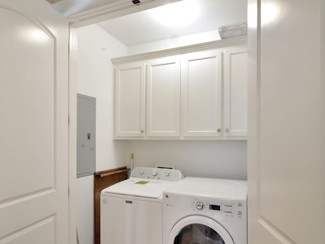 clothes washing area with electric panel, cabinets, and washing machine and clothes dryer