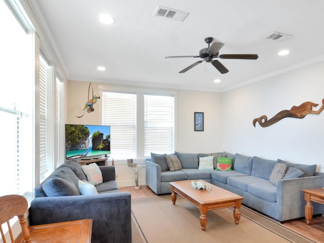 living room featuring light hardwood / wood-style flooring, ceiling fan, and ornamental molding