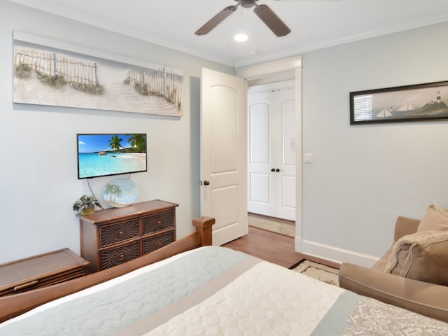 bedroom with ceiling fan, a closet, crown molding, and hardwood / wood-style floors