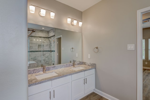 bathroom featuring baseboards, a sink, and a shower stall