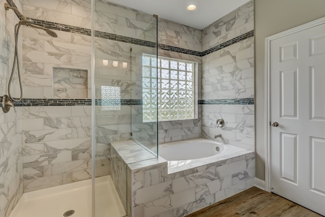 bathroom featuring a stall shower, wood finished floors, and a bath