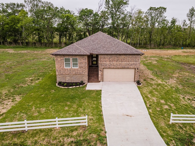 view of front of property featuring a front yard and a garage