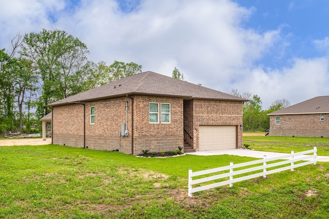 view of side of property featuring concrete driveway, brick siding, a yard, and fence