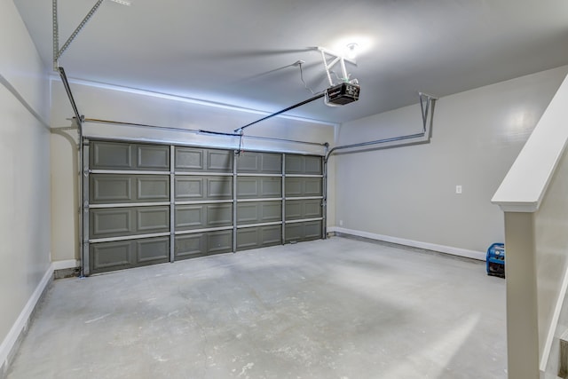 garage featuring a garage door opener and baseboards