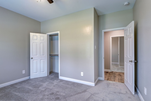 unfurnished bedroom with a closet, carpet flooring, and baseboards