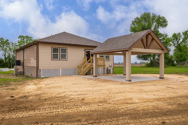 back of property featuring brick siding, a shingled roof, a gazebo, stairway, and a patio area