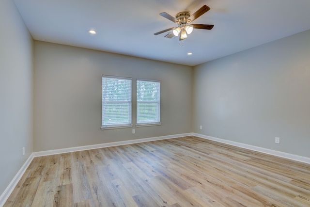 unfurnished room featuring light wood finished floors, ceiling fan, visible vents, and baseboards