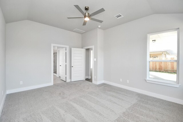 unfurnished bedroom featuring ceiling fan, light carpet, and vaulted ceiling