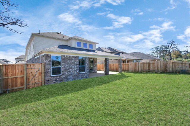 back of house with a lawn and a patio