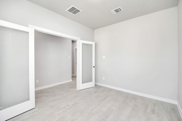 unfurnished bedroom featuring light hardwood / wood-style flooring and french doors