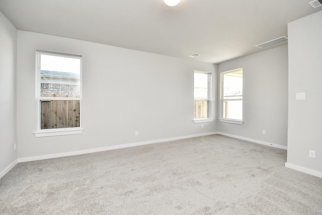 empty room featuring plenty of natural light and light carpet