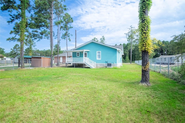 rear view of property featuring a yard and fence