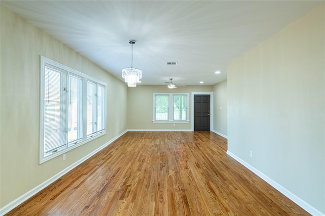 interior space with recessed lighting, visible vents, baseboards, light wood-style flooring, and ceiling fan with notable chandelier