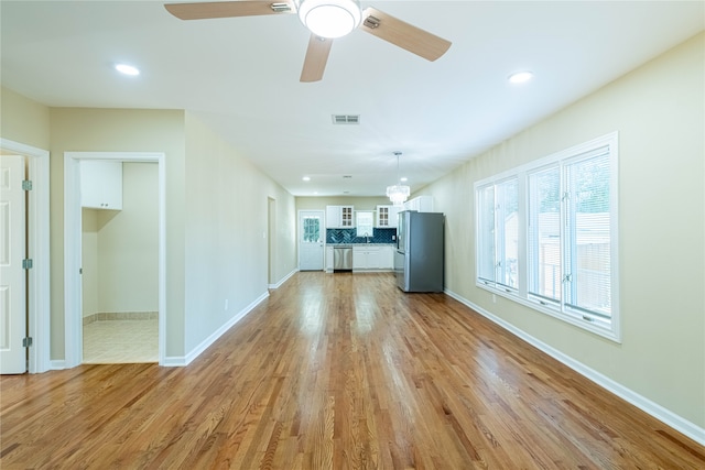 unfurnished living room featuring ceiling fan and light wood-type flooring