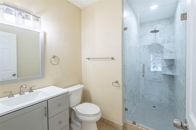 bathroom featuring tile patterned floors, toilet, an enclosed shower, and vanity