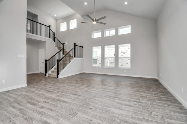 unfurnished living room featuring light hardwood / wood-style flooring, a healthy amount of sunlight, and high vaulted ceiling