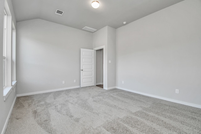 empty room with vaulted ceiling and light carpet