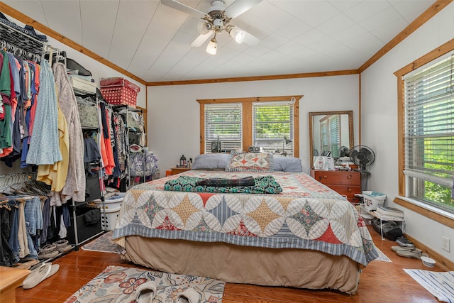 bedroom featuring multiple windows, wood-type flooring, crown molding, and ceiling fan