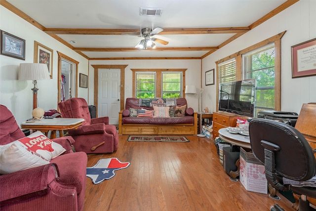 living room with a wealth of natural light, beam ceiling, ceiling fan, and hardwood / wood-style flooring