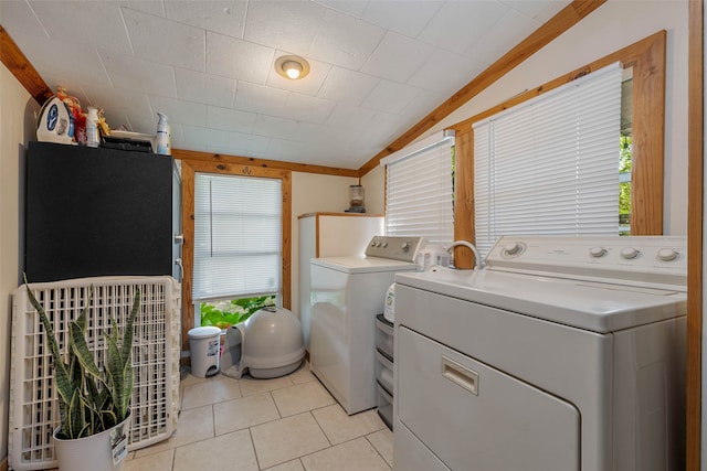 washroom with washing machine and clothes dryer, light tile patterned flooring, and ornamental molding