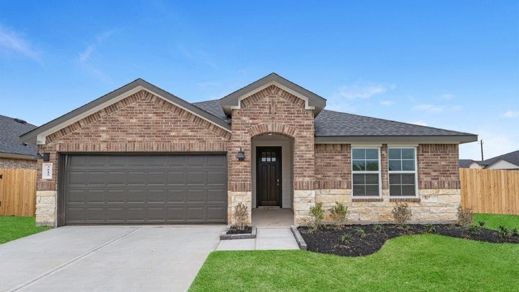 view of front of home with a front yard and a garage