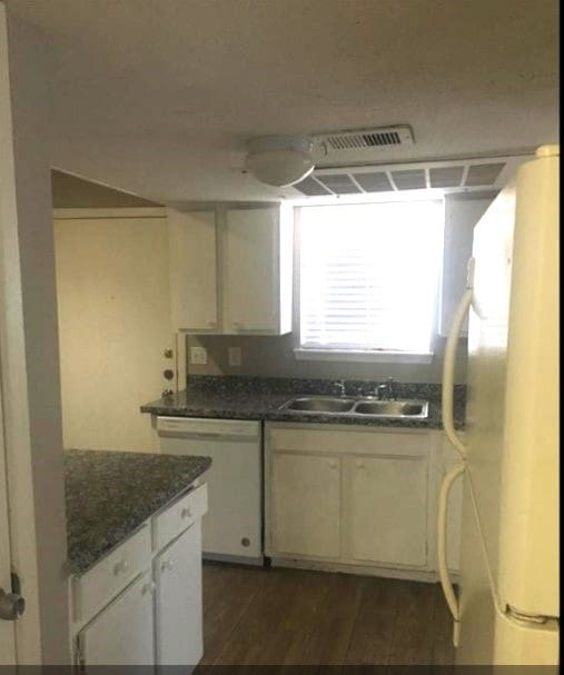 kitchen with sink, white cabinets, white appliances, dark wood-type flooring, and dark stone countertops