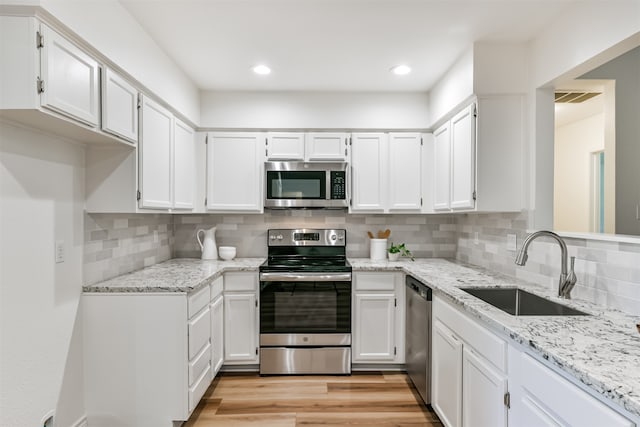 kitchen featuring sink, white cabinetry, light hardwood / wood-style floors, and stainless steel appliances