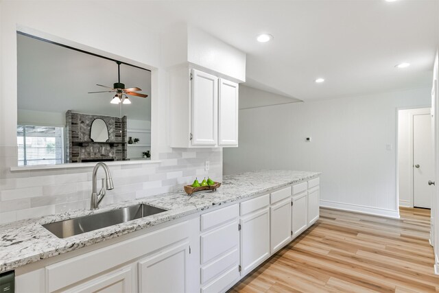 kitchen with ceiling fan, tasteful backsplash, white cabinets, light hardwood / wood-style floors, and sink