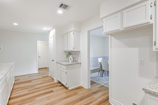 kitchen featuring white cabinetry, light hardwood / wood-style floors, and light stone countertops