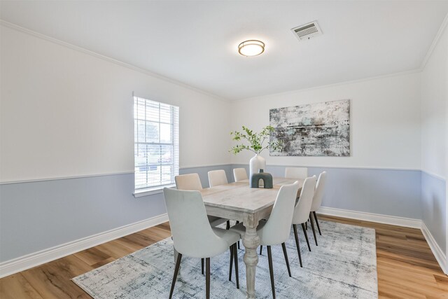 dining space featuring ornamental molding and wood-type flooring